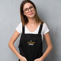 woman wearing a black apron with embroidery texan certified imprint from mytexasgift.com