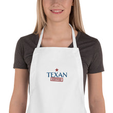 Load image into Gallery viewer, close up of a woman wearing a white apron with Texan Cerfified embroiderd on front offered by mytexasgift.com